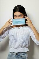 woman with Asian appearance face shield safety close-up light background unaltered photo