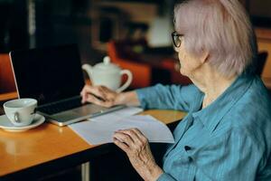 Senior woman documents work sheet of paper and pen Freelancer works unaltered photo