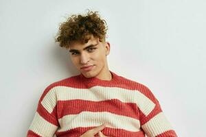 handsome guy in a striped sweater posing light background photo