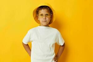 boy in yellow hat with glasses childrens fashion yellow background photo