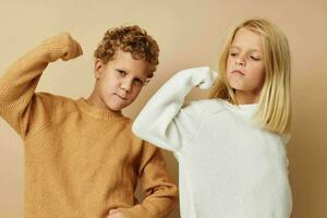 linda elegante niños en pie siguiente a posando emociones aislado antecedentes foto