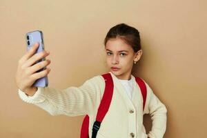 bonito joven niña Chica de escuela mochila teléfono en mano infancia inalterado foto