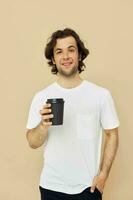handsome man in a white T-shirt with a black glass in hand Lifestyle unaltered photo