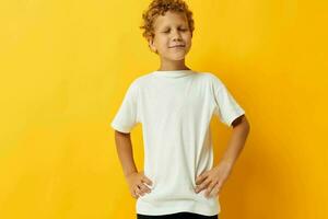 chico con Rizado pelo en un blanco camiseta en un amarillo antecedentes foto