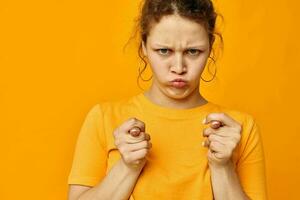 funny girl gestures with hands grimace emotions yellow background unaltered photo