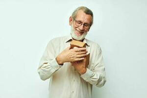 Old man with a small box in his hands in the studio alone photo