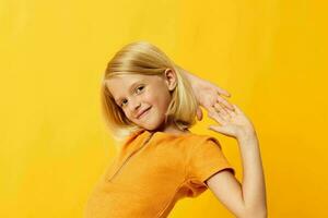 beautiful little girl smile hand gestures posing casual wear fun yellow background unaltered photo