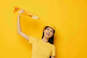 woman with Asian appearance cheerful woman with an airplane in the hands of fun isolated background unaltered photo