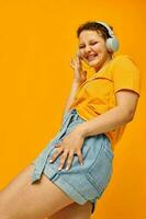 cheerful woman yellow t-shirt headphones entertainment music fun yellow background unaltered photo