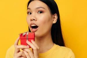 Portrait Asian beautiful young woman holding a gift box in his hands posing isolated background unaltered photo