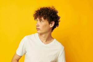 curly red-haired guy in a white t-shirt on a yellow background photo