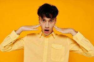 cheerful man in yellow shirt posing fashion gesture with hands photo