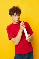 Young curly-haired man in a red t-shirt detergents in hands posing monochrome shot photo