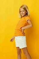 Little girl smile hand gestures posing casual wear fun yellow background unaltered photo