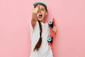 pequeño niña gorra en blanco camiseta patineta aislado antecedentes foto