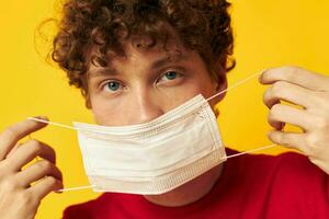 guy with red curly hair in protective masks safety posing yellow background unaltered photo