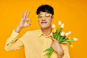 handsome guy give flowers wear spectacles yellow shirt isolated background unaltered photo