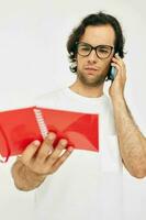 Attractive man in a white T-shirt red notepad Lifestyle unaltered photo