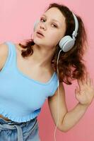 portrait of cute young girl in headphones listening to music pink background unaltered photo