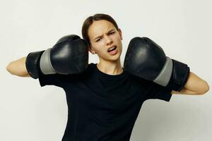 young beautiful woman in black sports uniform boxing gloves posing isolated background photo