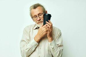 Senior grey-haired man in a shirt and glasses a black glass isolated background photo