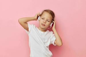 Portrait of happy smiling child girl in a white t-shirt with headphones childhood unaltered photo