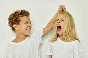 Boy and girl in white T-shirts are standing next to isolated background photo