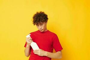 portrait of a young curly man detergents home care posing yellow background unaltered photo