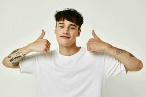 portrait of a young man tattoo on hands in white t-shirt light background unaltered photo