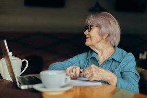 A businesswoman with glasses sits at a table in front of a laptop Social networks unaltered photo