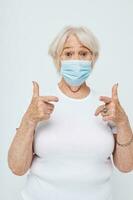 Portrait of an old friendly woman health lifestyle medical mask treatment light background photo