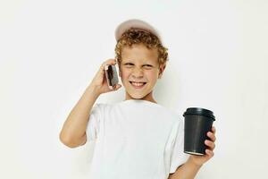 Photo portrait curly little boy talking on the phone with a black glass isolated background unaltered