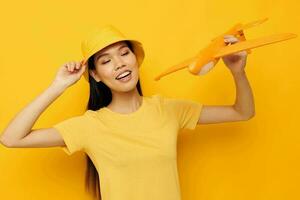 woman with Asian appearance cheerful woman with an airplane in the hands of fun isolated background unaltered photo