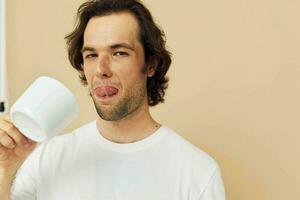 handsome man with a white mug in his hands emotions posing isolated background photo