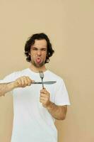 man in a white T-shirt with knife with fork Lifestyle unaltered photo