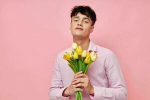 bonito hombre en un rosado camisa con un ramo de flores de flores gesticulando con su manos modelo estudio foto