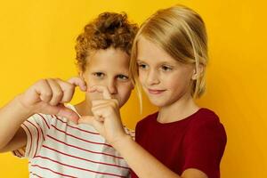 Portrait of cute children cuddling fashion childhood entertainment on colored background photo