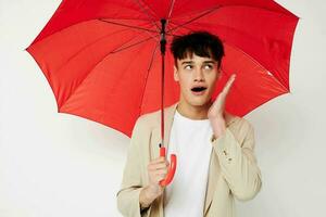 foto joven novio participación un paraguas en el manos de posando Moda ligero antecedentes inalterado