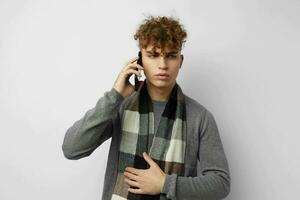 Attractive man in a plaid scarf looking at the phone fashion Lifestyle unaltered photo