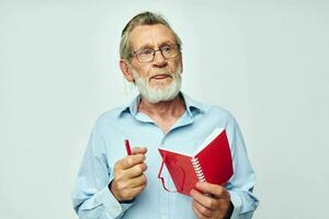 Portrait elderly man with red notebook and pen light background photo