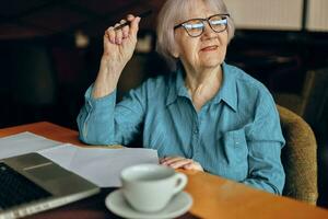 Happy senior woman sitting in a cafe with a cup of coffee and a laptop Lifestyle unaltered photo