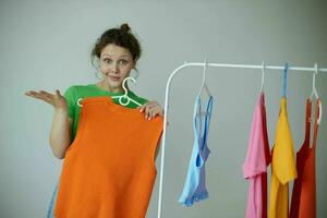 cheerful woman trying on clothes wardrobe Youth style yellow background unaltered photo