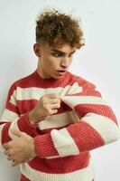 handsome young man in a striped sweater posing isolated background photo