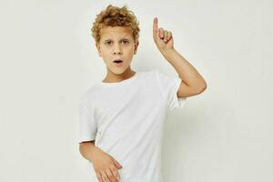 Photo of young boy in a white t-shirt posing fun isolated background