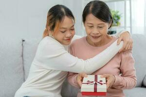 Mother day, cute asian teen girl give gift box to mature middle age mum. Love, kiss, care, happy smile enjoy family time. celebrating special occasion, happy birthday, happy new years, merry Christmas photo