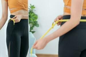 dieta y dieta. cinta métrica de uso de cuerpo femenino delgado de belleza. mujer con ropa de ejercicio logra el objetivo de pérdida de peso para una vida saludable, loca por la delgadez, cintura delgada, nutricionista. foto