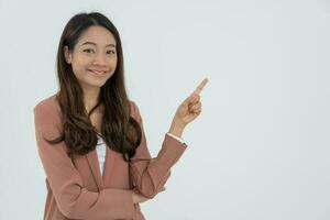 Portrait asian beautiful girl pointing blank space isolated background. Business woman pointing on something. young female standing pointing finger sideways, billboard, introduction, advertisement photo