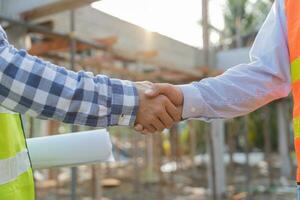 Construction worker team hands shaking greeting start up plan new project contract in office center at construction site, industry ,architecture, partner, teamwork, agreement, property, contacts. photo