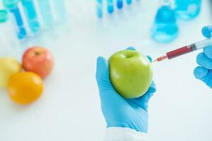 científico cheque químico comida residuos en laboratorio. controlar expertos inspeccionar calidad de fruta, científicos inyectar productos quimicos dentro manzanas para experimentos, peligros, prohibido sustancia, contaminar foto