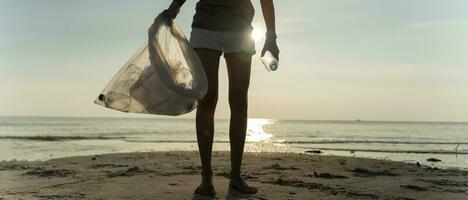 salvar océano. voluntario recoger arriba basura basura a el playa y el plastico botellas son difícil descomponer evitar daño acuático vida. tierra, ambiente, verdeado planeta, reducir global calentamiento, salvar mundo foto